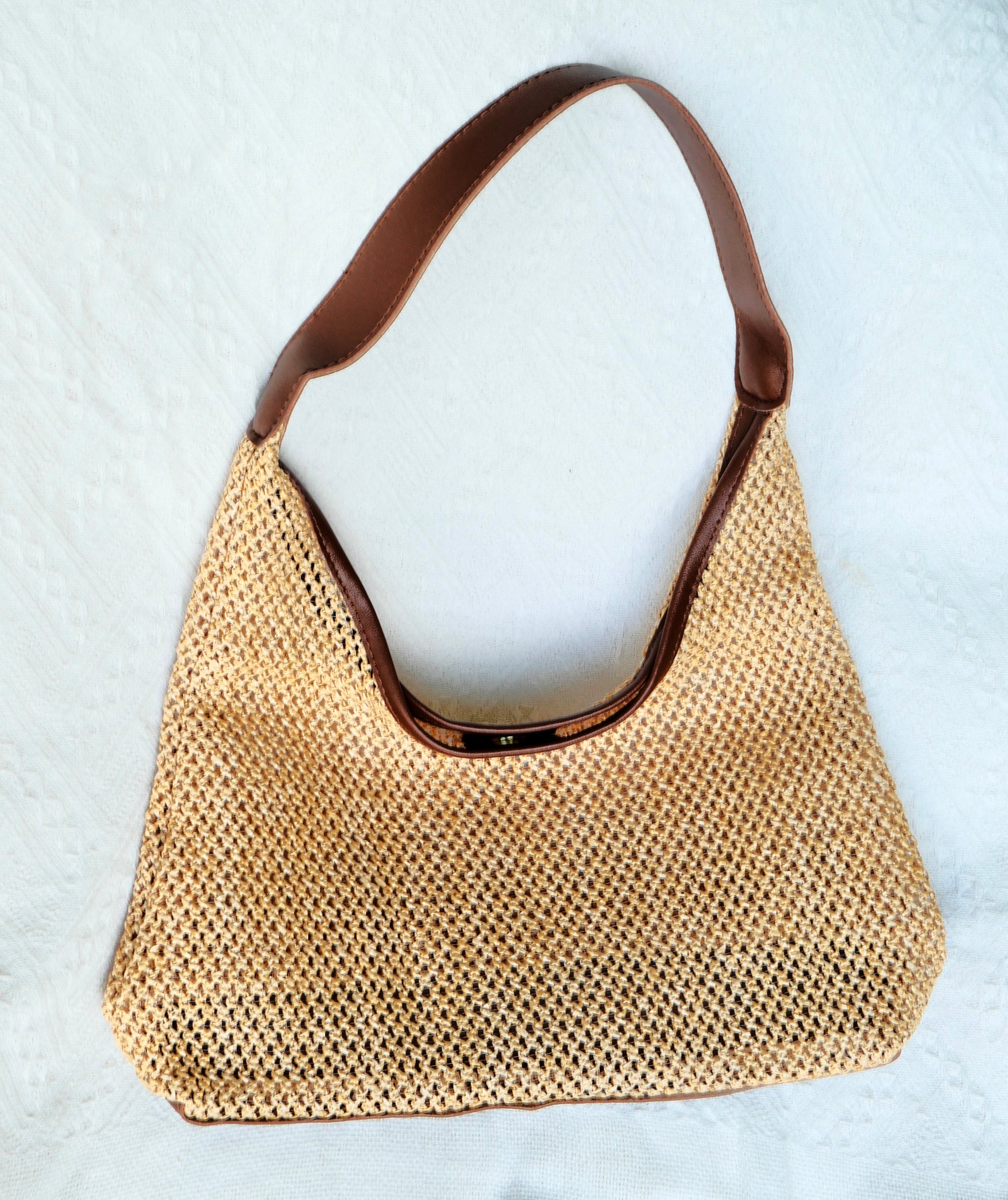Full front viw of straw beach bag with brown leather straps 