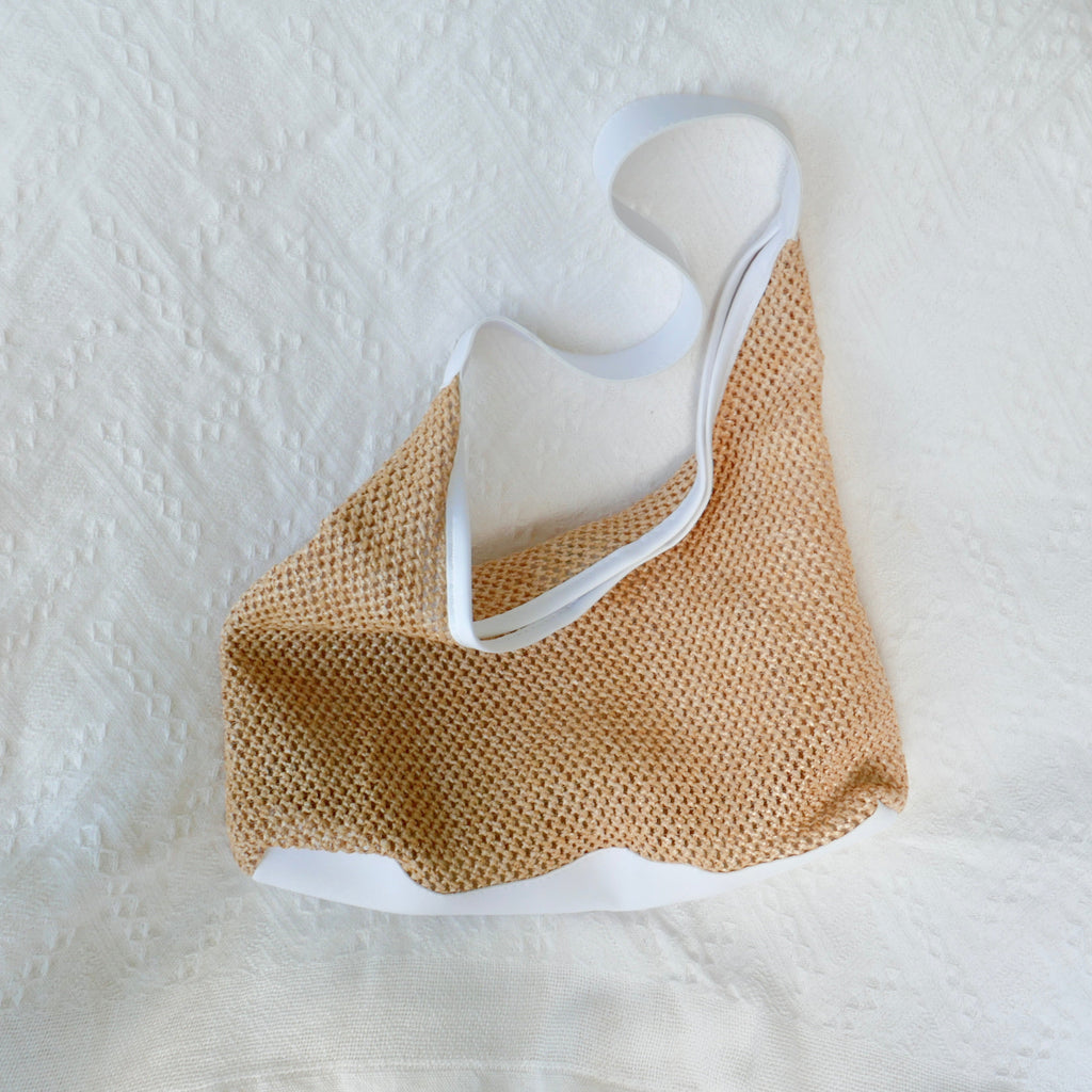 full front side picture of a straw beach bag with white leather straps